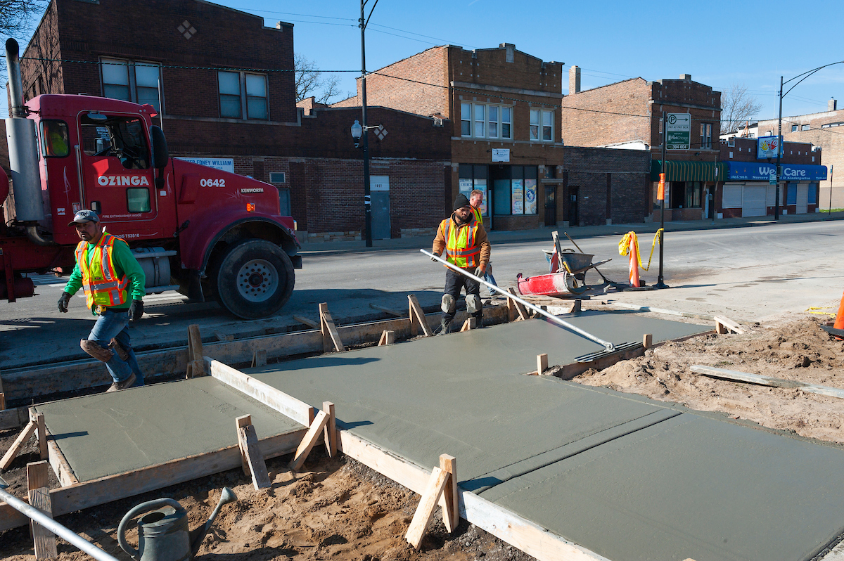A photo of crews pouring concrete as part of installing an ADA ramp