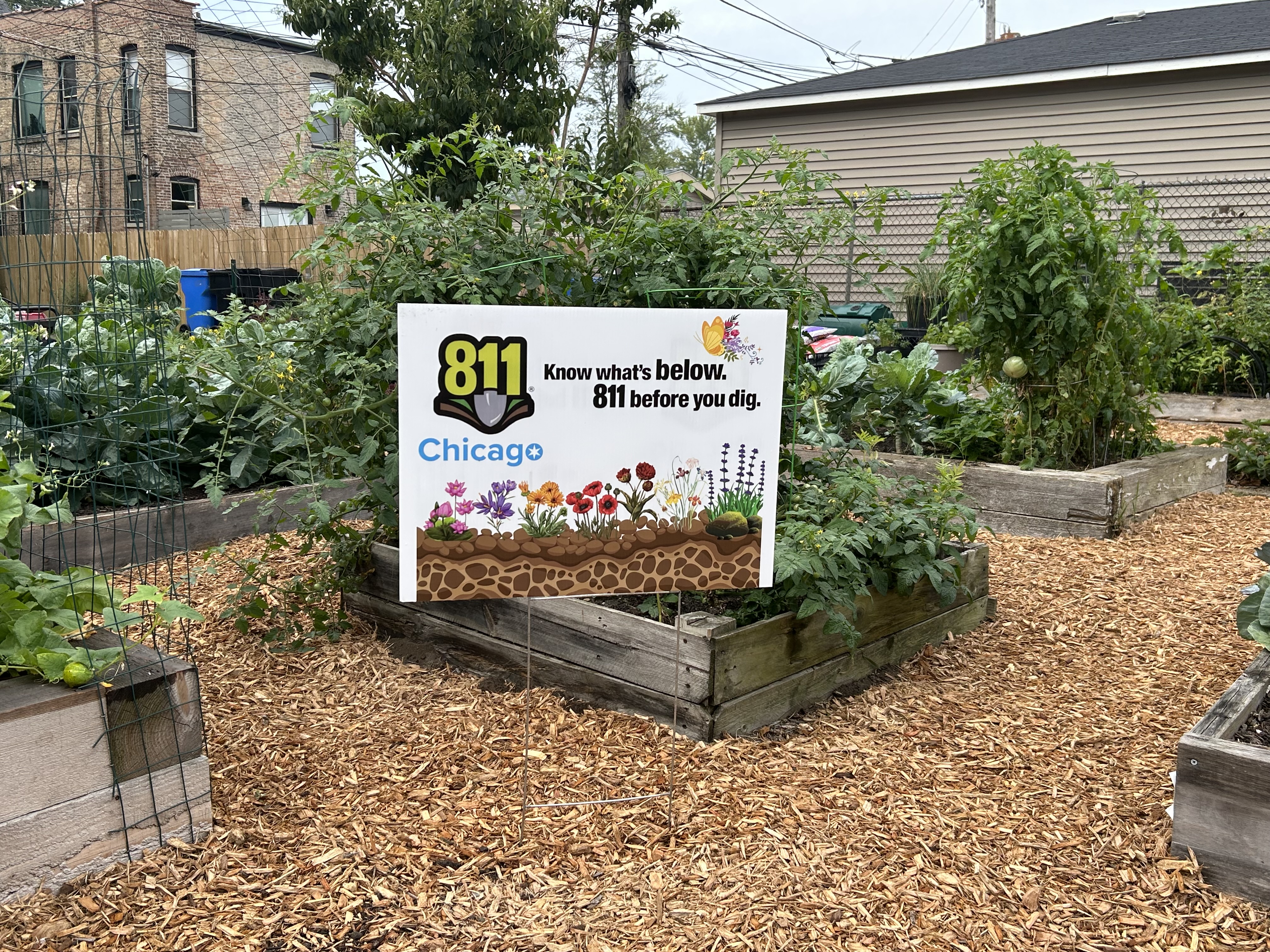 Raised garden beds with a sign that says "811 Chicago Know What's Below. 811 Before You Dig"