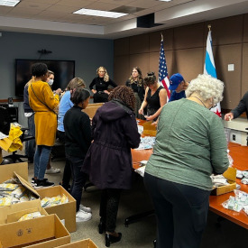 thumbnail - Volunteers around a table packing Narcan and other supplies into harm reduction bags