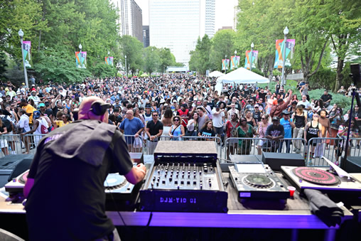 Chicago House Music Festival and Conference (DJ on stage with crowd cheering in the background)