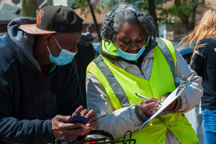 Corridor Ambassador holding clipboard to resident 