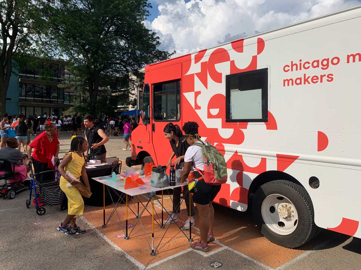 Image of Mobile Makers event with a white food truck painted with their red logo 