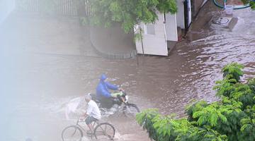 Photo of people trying to cross a flooded street