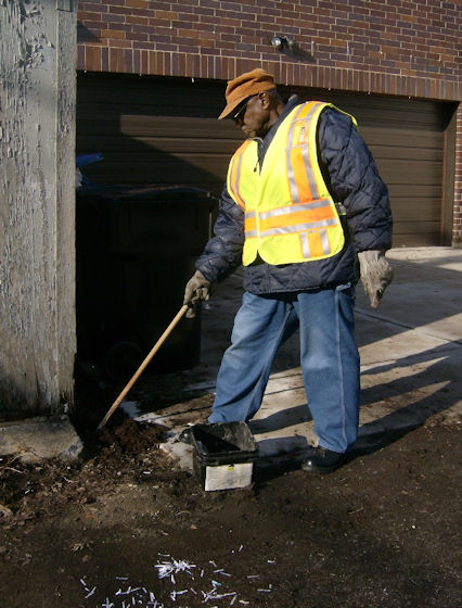 Rodent Control Worker Baits a Rodent Burrow