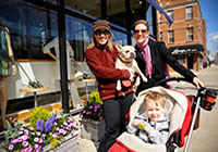 Two women, one holding a dog and the other a stroller with a child