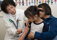 A female doctor giving a young girl an injection