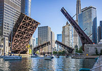 Traffic moving under a bridge with an elevated train going by above