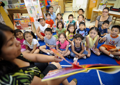 Teacher reads to a group of children in school