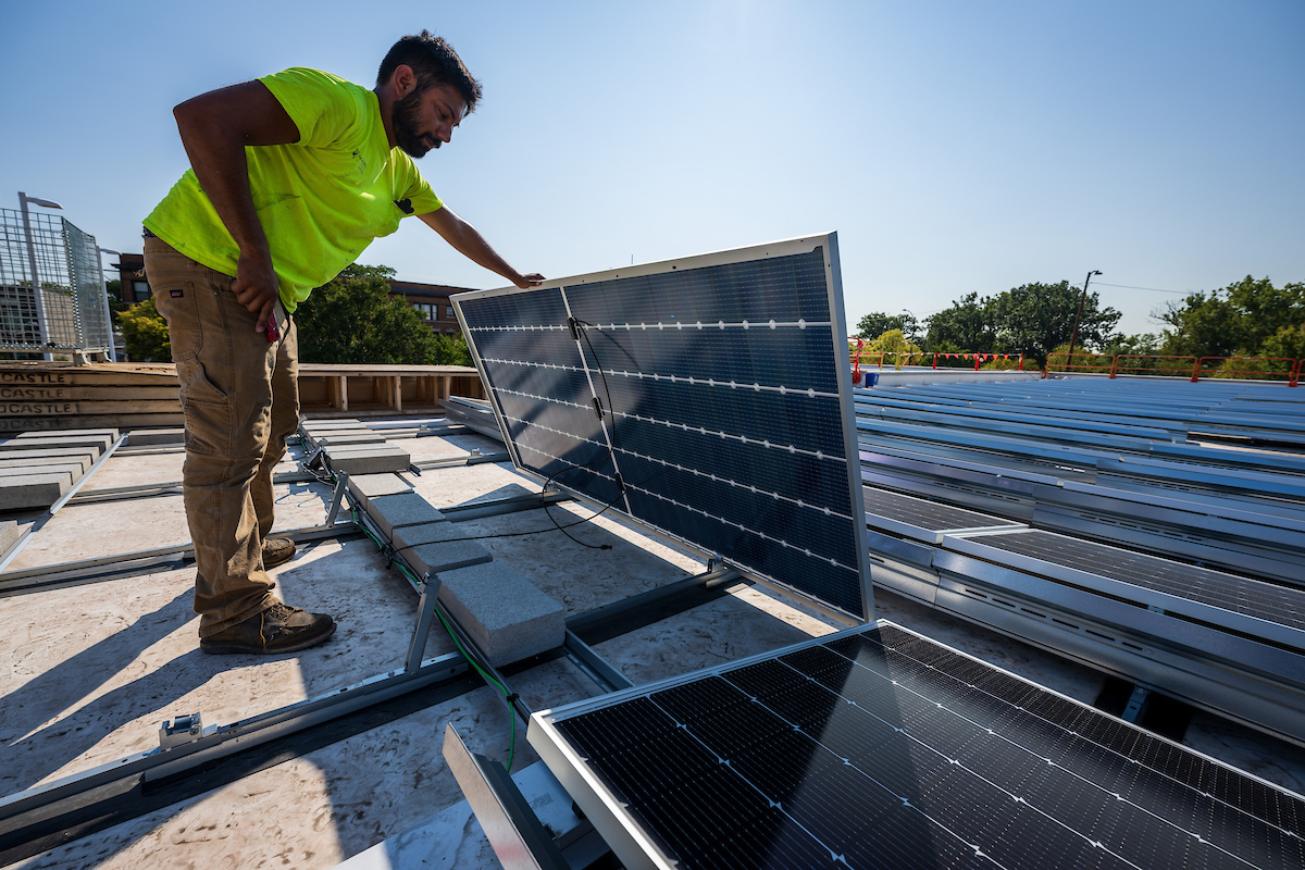 Worker installs solar panel on the roof of the Humboldt Park Branch Library in Chicago's Humboldt Park neighborhood
