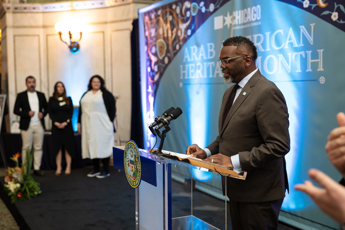 Mayor Brandon Johnson speaking at a podium at the Arab American reception.