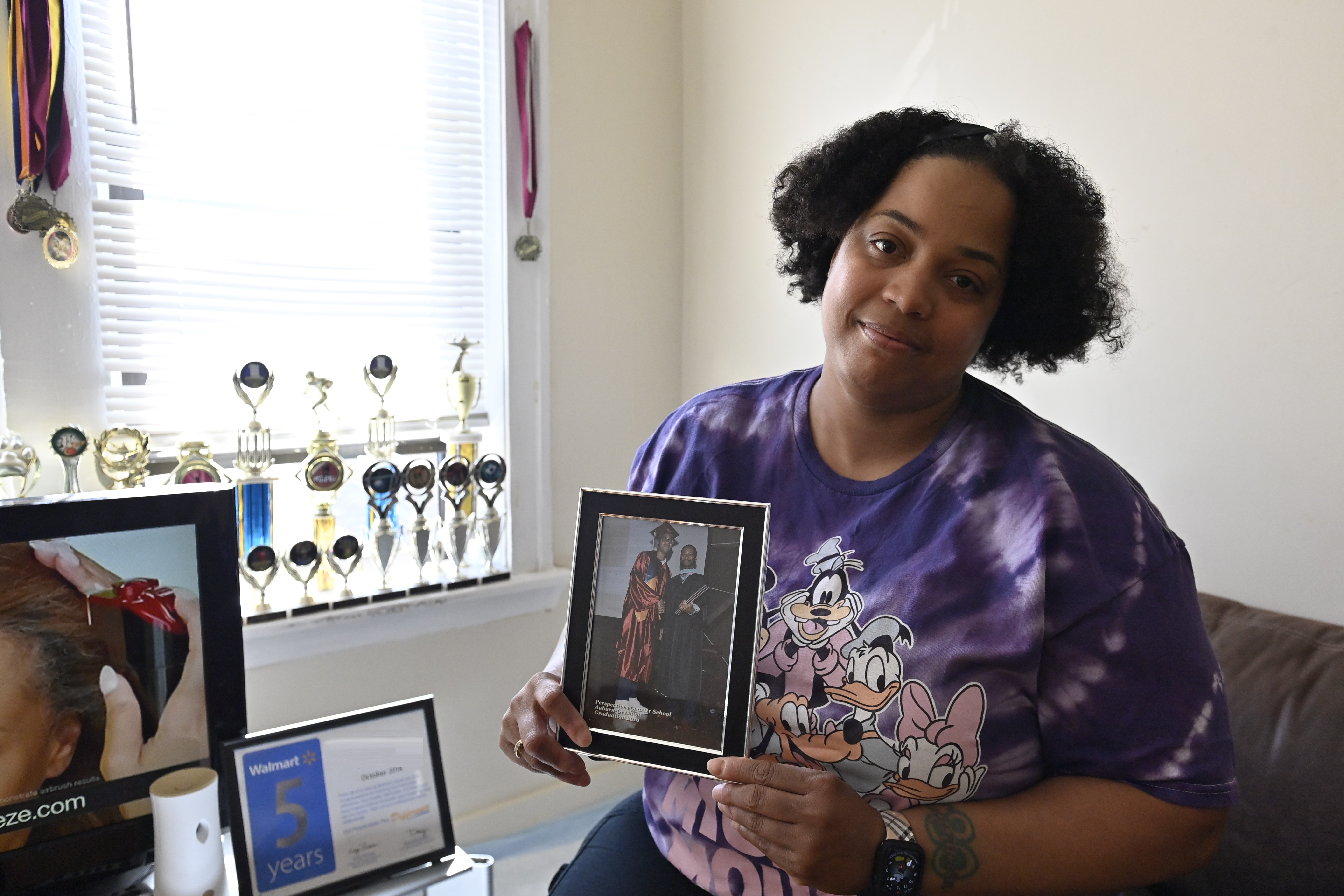 Woman holding up graduation photo.