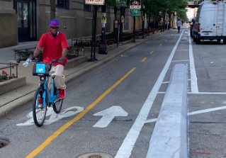 person riding bike waiting at protected intersection