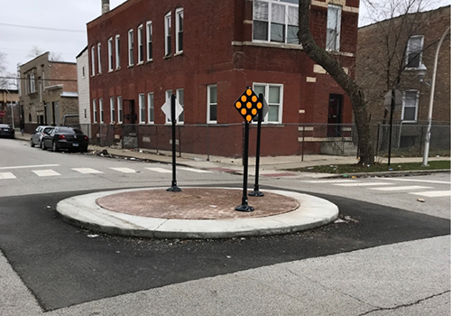 Traffic circle in center of intersection with signage