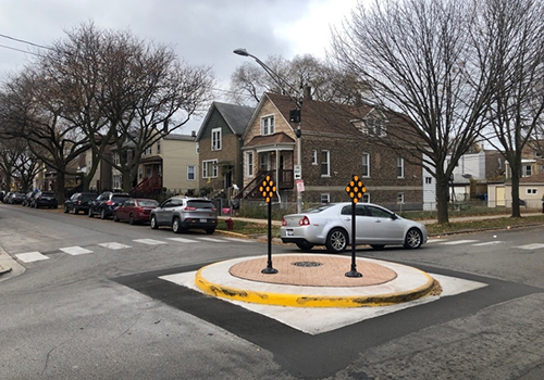 neighborhood traffic circle with car passing through