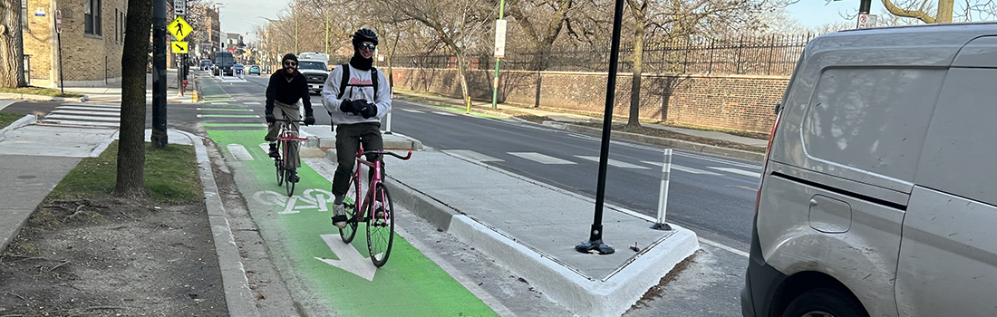 View of street with person riding a bike protected by a concrete median