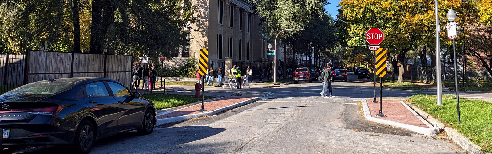 Students crossing the street in a cross with detached bumpouts narrowing the crossing distance