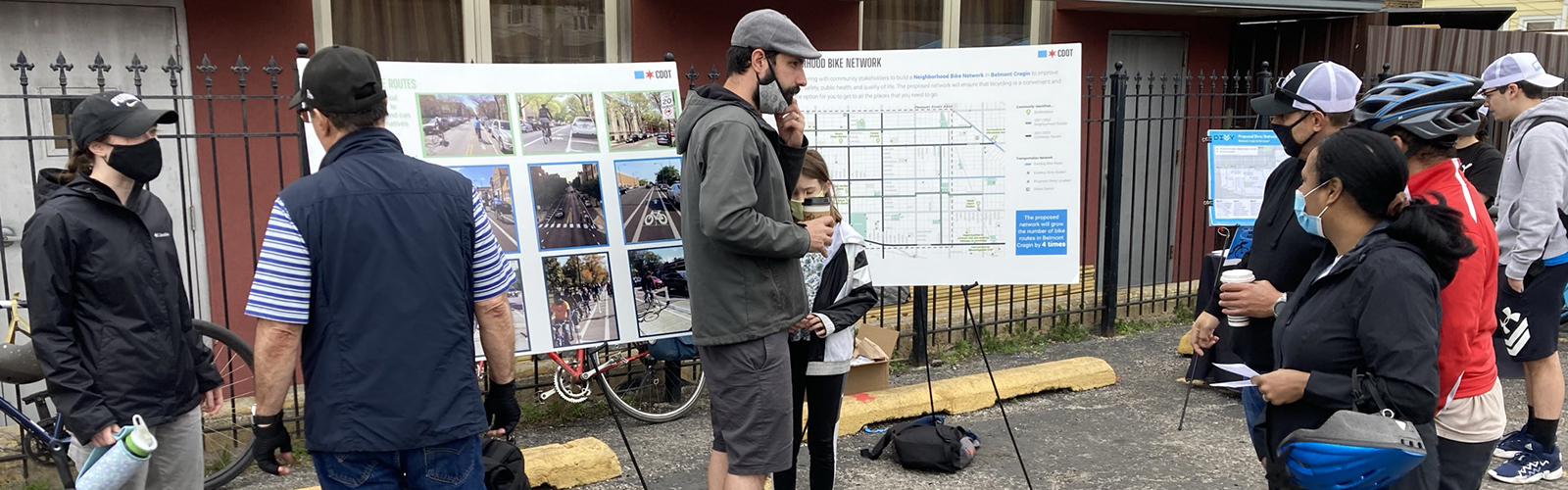 Group of people surrounded by bikes and posters giving community feedback