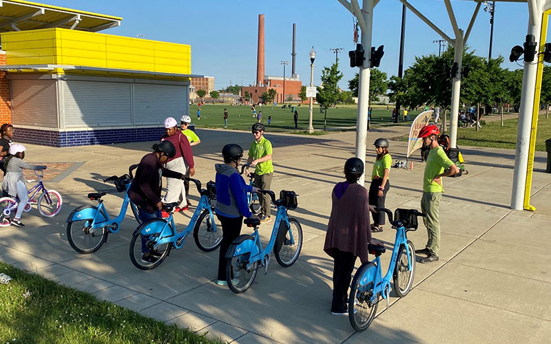 SAFE Ambassadors staff standing in front of group of people, each holding a blue Divvy bike