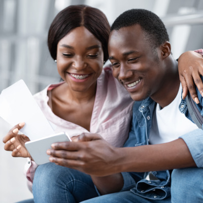 tab 01 image - Couple looking enthusiastically at travel documents together Couple looking enthusiastically at travel documents together