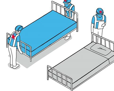 three people setting up hospital beds