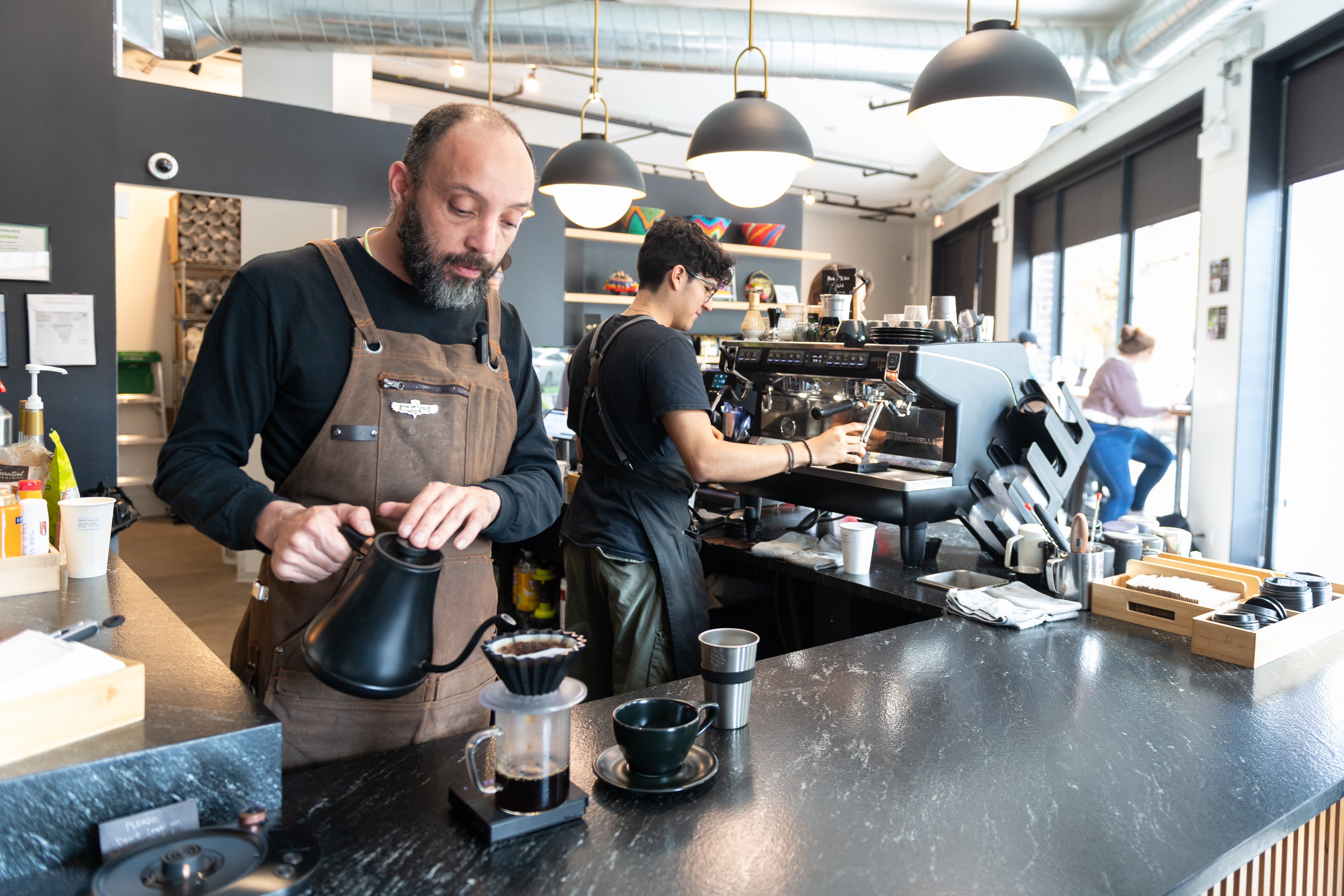 Owner and worker making coffee orders 