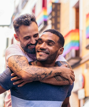 Photo of two men embracing in street scene with rainbow flags