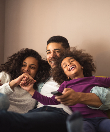 Photo of a happy family cuddling together on a couch