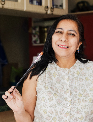 Smiling woman holding paint brush