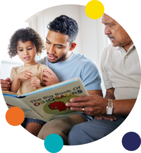 A father and grandfather reading a storybook to a young girl