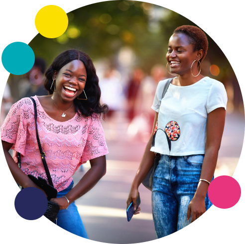 Two women smiling and laughing in outdoor setting