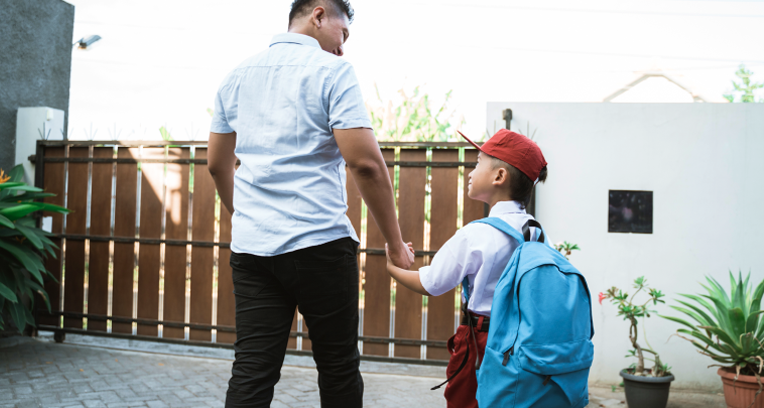Young child with big backpack, holding adult's hand