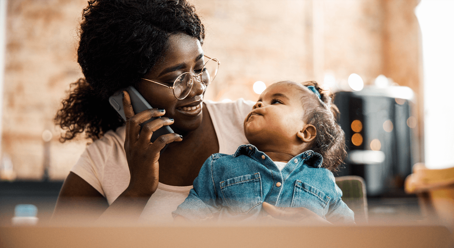 Mother on phone holding baby