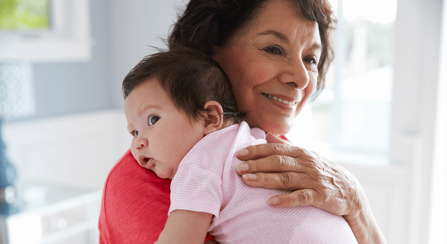 infant being held against older woman's shoulder