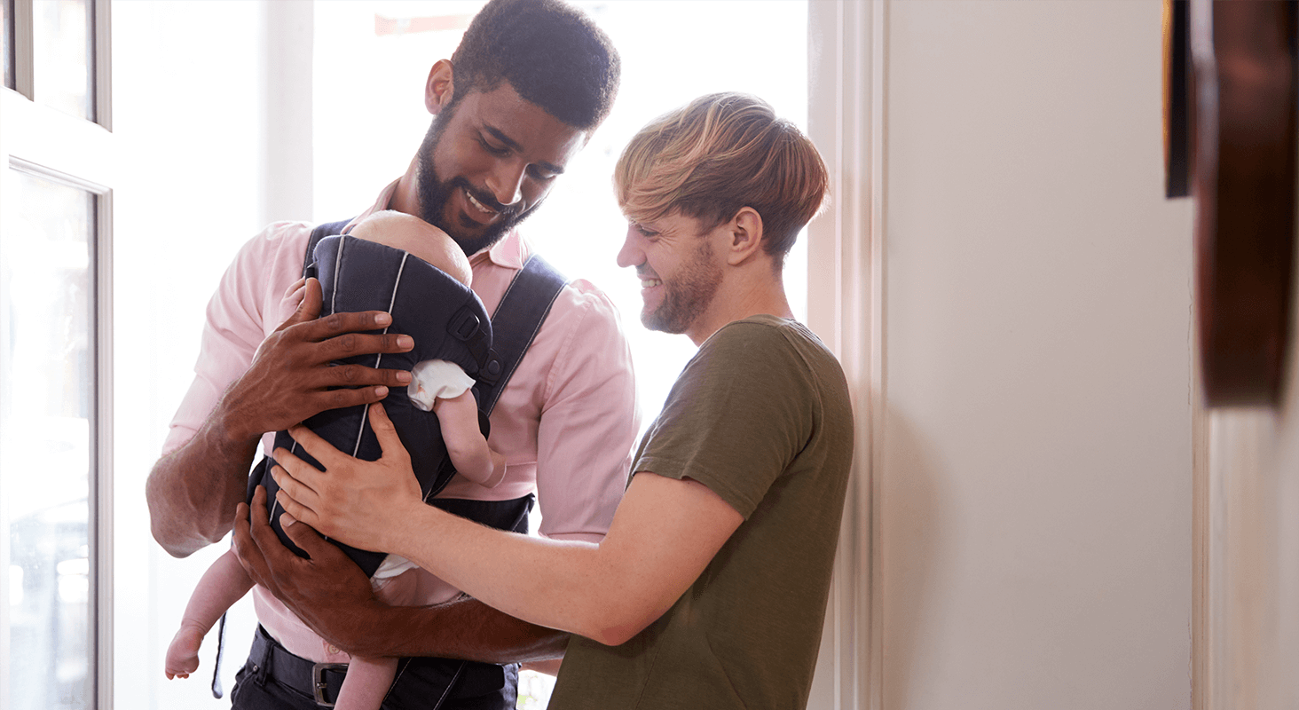 Parents Admiring Infant in Carrier